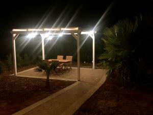 a table and chairs under a pavilion at night at STELLA MARINA B&B in Alliste