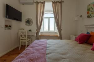 a bedroom with a bed with a window and a desk at Casa do Povo in Elvas +78 photos
