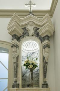 einen Altar mit Kreuz und eine Vase mit Blumen in der Unterkunft Casa do Povo in Elvas