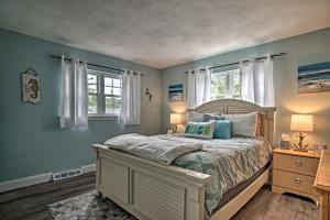 a bedroom with a bed with blue walls and windows at Walk to Beach Quaint Dennis Home with Deck and Grill! in Dennis
