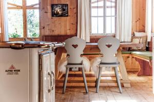 two white chairs with hearts on them in a kitchen at Talsenalm Wald Habitat in Waidring