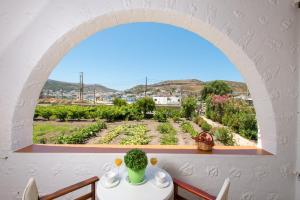 a room with an arched window looking out at a garden at Stefanos Studios in Skala