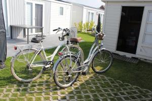 克諾克－海斯特的住宿－Familie-Vakantiehuisje aan Zee (Knokke-Heist)，两辆自行车停在房子外面,彼此相邻