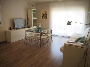 a living room with a glass table and a television at Apartament per families a Sant Feliu amb piscina in Sant Feliu de Guixols