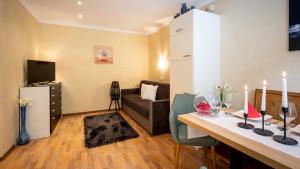 Una pequeña sala de estar con una mesa y un sofá. en St. Lukas Apartments, en See
