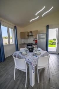 ein Esszimmer mit Tisch und Stühlen und eine Küche in der Unterkunft LA STELLA DEL SUD in Marsala + 17 Fotos