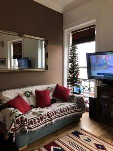 a living room with a couch and a christmas tree at Skippers View Sunny Balcony in Eastbourne