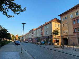 een straat met gebouwen aan de kant van een weg bij Mitten im Herzen von Neubrandenburg in Neubrandenburg