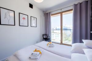 a bedroom with two beds and a large window at ApartHotel Kolejowa Apartamenty in Warsaw
