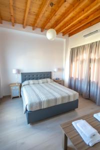 a bedroom with a bed and a wooden ceiling at Stefanos Studios in Skala