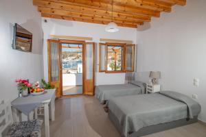 a bedroom with two beds and a table with a table sidx sidx sidx at Stefanos Studios in Skala