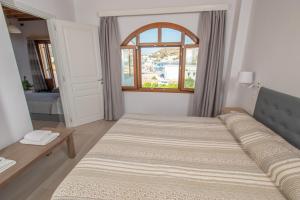 a bedroom with two beds and a window at Stefanos Studios in Skala