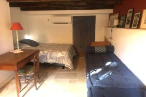 um quarto com uma cama, uma secretária e uma mesa em Magnifique maison de village clim vue mer 6 pers em Bormes-les-Mimosas
