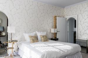 a bedroom with a white bed with two pillows at Molenmeers Boutique Guesthouses in Bruges