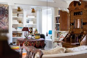 a living room with a table and bookshelves at Molenmeers Boutique Guesthouses in Bruges