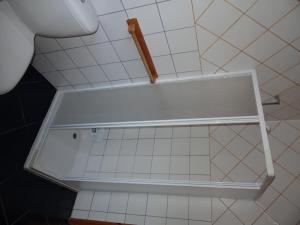 a white shelf in a bathroom with white tiles at Casa da Alícia in Feiteira