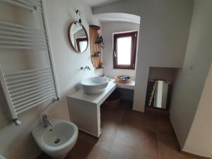 a bathroom with a sink and a toilet and a mirror at Mamapulia Home in Alberobello