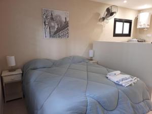 a bedroom with a blue bed with a fan at Aylen Departamentos en Pinamar NO GRUPO DE JOVENES in Pinamar +38 photos