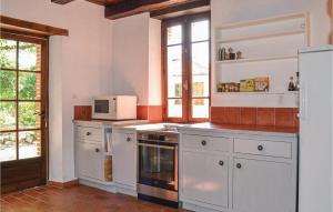 a kitchen with a stove and a microwave at Beautiful Home In Durfort Lacapelette in Durfort