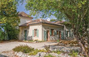 une maison blanche avec des fenêtres vertes et un arbre dans l'établissement Stunning Home In Durfort Lacapelette With 6 Bedrooms, Internet And Private Swimming Pool, à Durfort