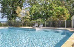 a swimming pool with two chairs in the water at Beautiful Home In Durfort Lacapelette in Durfort