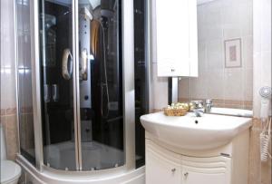 een badkamer met een wastafel, een douche en een wastafel bij Cherepanovs' Guest House in Esto-Sadok