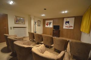 a waiting room with chairs and a tv in a room at Hotel Cristallo in Madonna di Campiglio