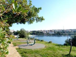 a park next to a body of water with a bench at Apartments Estelle in Pula
