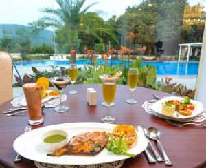 a table with plates of food and drinks on it at Park Regis Goa in Arpora