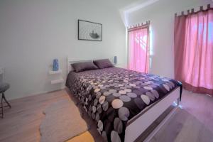 a bedroom with a bed in a room with pink curtains at Apartments Estelle in Pula