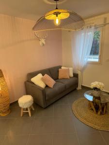 sala de estar con sofá y mesa en Studio calme et cosy, en Saint-Julien-les-Villas
