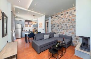 a living room with a couch and a brick wall at Casa Kaneli Luxury Villa Elounda in Elounda