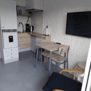 una pequeña cocina con mesa y TV en la pared en Apartament Beti, en Oostkamp