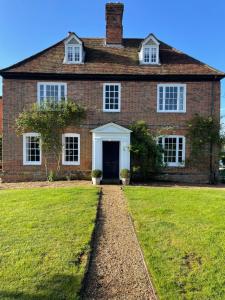 una gran casa de ladrillo con un patio de hierba en Little Park Farm Queen Anne Farmhouse & Apartments, en Stratfield Mortimer