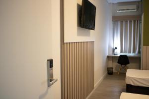 um quarto com um radiador e uma televisão na parede em Hotel Jardim Sul em São José dos Campos