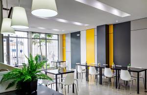 a dining room with black tables and white chairs at Hotel Médano in Trujillo
