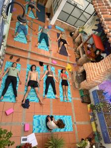 a group of people sitting on mats in a pool at Hostal La Isla in San Cristóbal de Las Casas