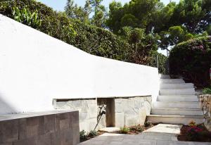 a white wall with a set of concrete stairs at Studio Agia Marina Koropi in Aghia Marina