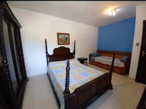 une chambre avec deux lits et un mur bleu dans l'établissement Casa de Praia Ibicuí, à Mangaratiba
