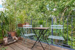 a table and two chairs on a deck with plants at Cosy 2 Bedroom Apartment with Great Outdoor Balcony in London