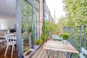 a balcony with a wooden bench and a table with plants at Cosy 2 Bedroom Apartment with Great Outdoor Balcony in London