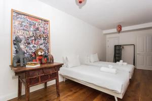 a bedroom with a bed and a painting on the wall at Cosy 2 Bedroom Apartment with Great Outdoor Balcony in London