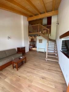 a living room with a couch and a staircase at Hotel & Restaurant Pahor in Doberdò del Lago