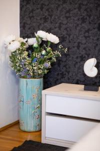 a vase filled with flowers sitting next to a dresser at La Conac in Arad
