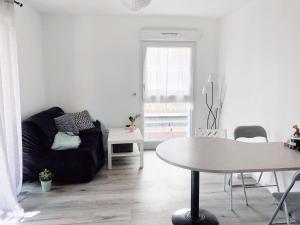 a living room with a black couch and a table at Appartement Muse proche Gare in Metz +17 photos