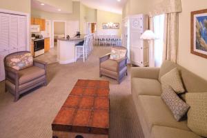a living room with a couch and chairs and a kitchen at Club Wyndham at The Cottages in Myrtle Beach