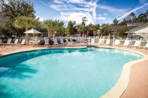 a large swimming pool with chairs and a white fence at Club Wyndham at The Cottages in Myrtle Beach