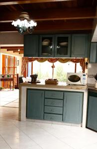 a kitchen with green cabinets and a microwave at La Morada del Sol in Tausa Viejo