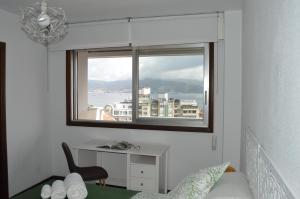 a bedroom with a window with a desk and a deskablish at Fantástica vista de la Ría de Vigo en pleno centro in Vigo