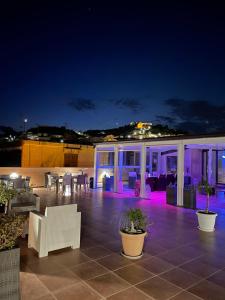 a patio with white chairs and tables at night at Case Vacanze Al Duomo in Licata